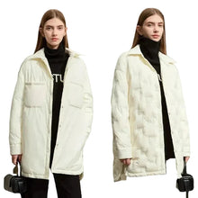Two models wearing AMII off-white quilted puffer jackets over black turtlenecks, standing against a light beige studio background.