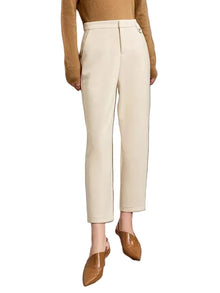 A model wearing AMII cream-colored high-waisted straight-leg trousers, styled with a tan sweater and brown pointed-toe mule flats against a minimalist beige wall.